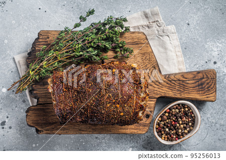 Roast pork roulade Porchetta, pork meat meal on a wooden board. Gray background. Top view Roast pork roulade Porchetta, pork meat meal on a wooden board. Gray background. Top view 95256013