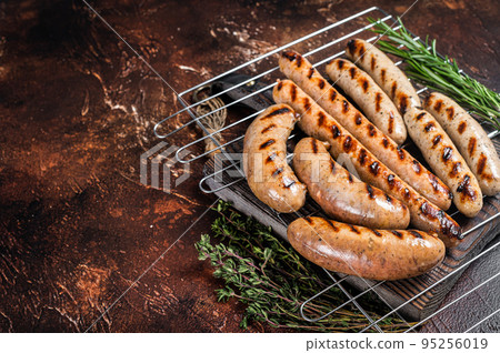 Assortment of different bbq grilled sausages with Beef, pork, lamb and chicken meat on a grill. Dark background. Top view. Copy space Assortment of different bbq grilled sausages with Beef, pork, lamb and chicken meat on a grill. Dark background. Top view. Copy space 95256019