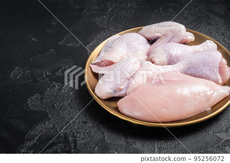Fresh raw chicken meat with various parts - drumstick, breast fillet, wings, thigh. Black background. Top view. Copy space 95256072