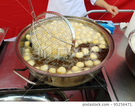 Cooking fry curd balls in boiling hot oil 95256471