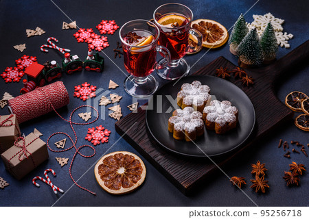 Hot mulled wine with a slice of orange, with cinnamon, cloves and other spices Hot mulled wine with a slice of orange, with cinnamon, cloves and other spices 95256718