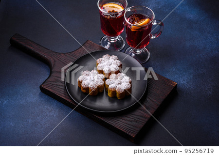 Hot mulled wine with a slice of orange, with cinnamon, cloves and other spices Hot mulled wine with a slice of orange, with cinnamon, cloves and other spices 95256719