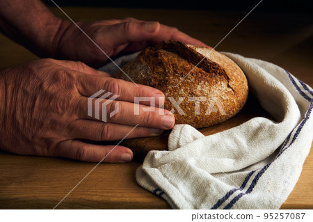 black bread in men's hands 95257087
