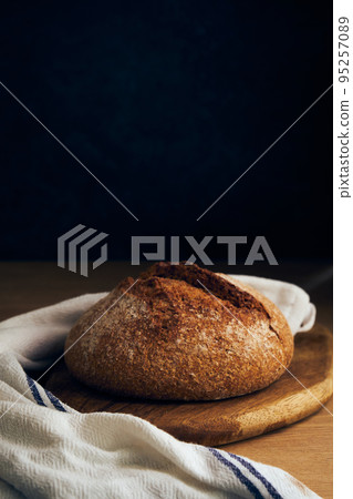 a loaf of bread on a wooden board 95257089