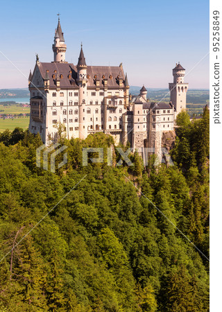 Neuschwanstein Castle in forest, Germany. Vertical view of old German palace 95258849