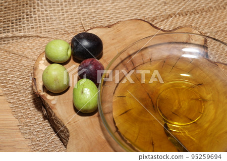 Olives and Olive Oil on wooden background 95259694