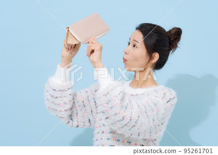 A woman in her twenties with a wallet A woman in her twenties with a wallet 95261701
