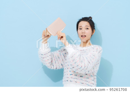 A woman in her twenties with a wallet 95261708