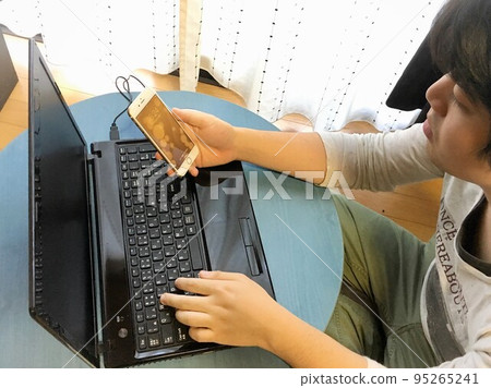 A man typing on a computer at home 95265241