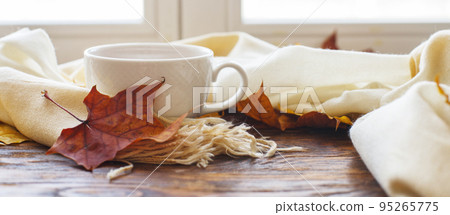 autumn leaves with a cup of tea or coffee next to a scarf on a wooden background banner autumn leaves with a cup of tea or coffee next to a scarf on a wooden background banner 95265775