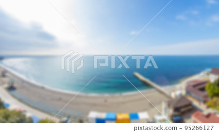 Abstract defocused sea view with clear blur sky, view from high floor of luxury hotel apartment room terrace. Blurred background view from the balcony to the sea on sunny day. City near the sea. 95266127