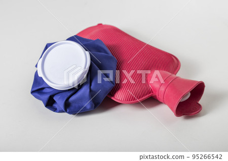 Red medical water heater and blue ice bag on a white background. The concept of treating diseases with heat and cold, heat therapy. First aid for pain and inflammation Red medical water heater and blue ice bag on a white background. The concept of treating diseases with heat and cold, heat therapy. First aid for pain and inflammation 95266542