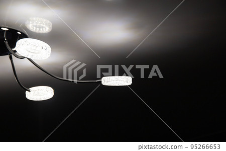 Modern LED chandelier on the ceiling of the house. Lighting with diodes, close-up Modern LED chandelier on the ceiling of the house. Lighting with diodes, close-up 95266653