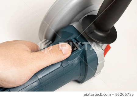 Activation of an angle grinder with soft start function. Close-up 95266753