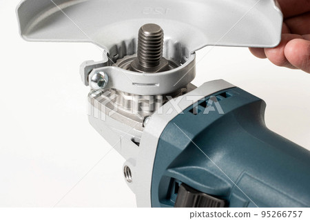 Installing the safety cover on an angle grinder, close-up. Safety precautions when working with construction power tools. 95266757
