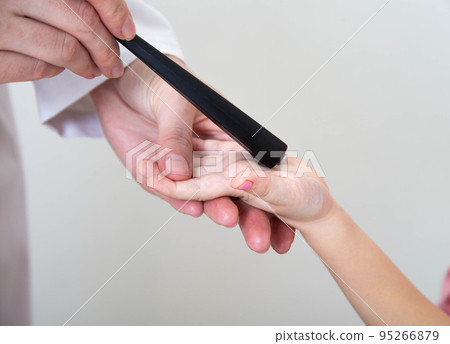 A neurologist examines a girl s palm chin reflex with a neurological hammer. Cervicocranialgia and oral automatism, close-up 95266879