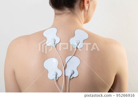 medical electric acupuncture massager on the body of a girl. Fat burning and health promotion. Physiotherapy, close-up 95266916