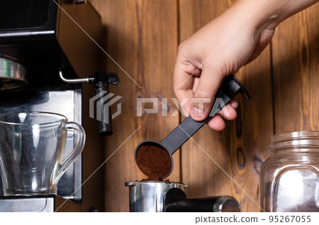 A man pours coffee into the horn of a manual coffee maker. Making a delicious, invigorating cappuccino and americano, close-up 95267055