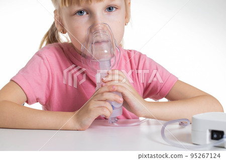 A 5-year-old caucasian girl is breathing into an inhaler at home. Treatment of cough and lung diseases in children, dilution of phlegm in the bronchi. 95267124