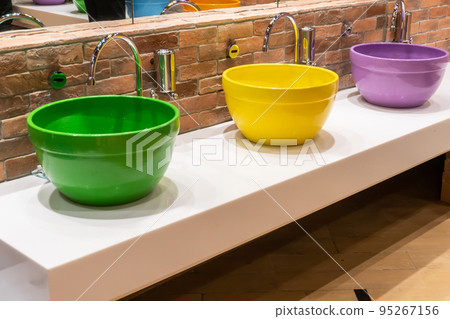 Colorful wash basin or sinks with modern water discharge sensors. 95267156