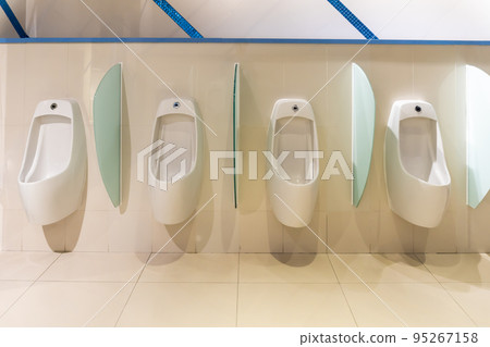 White urinal with a row of automatic pouring sensors and a stopper in a modern supermarket. 95267158