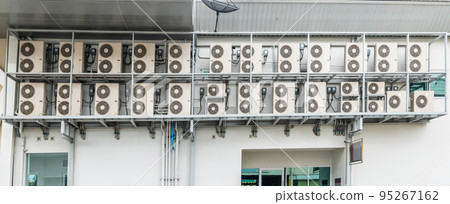 Many air conditioners units compressor are attached to the sides of large buildings for cooling. 95267162