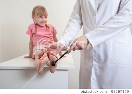 Doctor neuropathologist checks the plantar reflex on the leg of a little girl. Treatment and diagnosis of neurological diseases 95267169