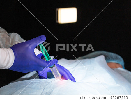 Doctor proctologist with a syringe with a medicine in his hands. Procedure for the treatment of hemorrhoids and anal diseases, sclerotherapy Doctor proctologist with a syringe with a medicine in his hands. Procedure for the treatment of hemorrhoids and anal diseases, sclerotherapy 95267313