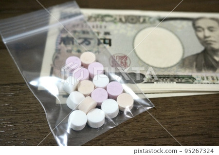 Image of pills and money in a sachet 95267324