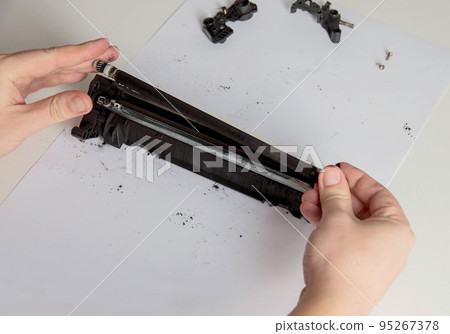 Disassembly of a drum cartridge on a white background. Cleaning and maintaining cartridge parts. Copy space for text 95267378