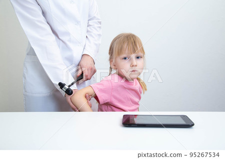Doctor neurologist checks triceps reflex in a girl age 5 years patient. Examination by a neurologist in the office, medical, nervous system. Copy space for text Doctor neurologist checks triceps reflex in a girl age 5 years patient. Examination by a neurologist in the office, medical, nervous system. Copy space for text 95267534