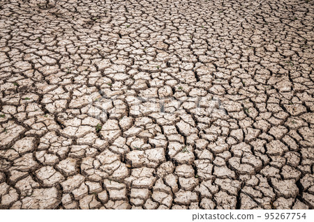 Dry soil cracked in an arid environment without water. Copy space background, texture 95267754