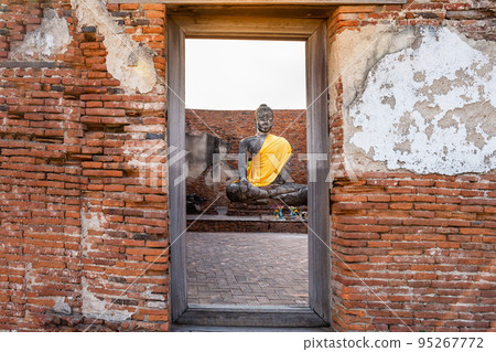 A large Buddha statue, a view through an ancient gate at Wat Lokaya Sutharam, Ayutthaya Province, Thailand. A large Buddha statue, a view through an ancient gate at Wat Lokaya Sutharam, Ayutthaya Province, Thailand. 95267772