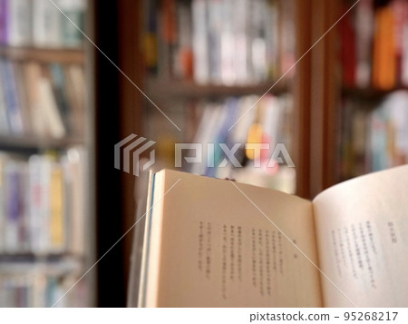 open the book in front of the bookshelf 95268217