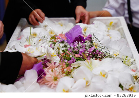 Relatives laying flowers on the coffin Relatives laying flowers on the coffin 95268939