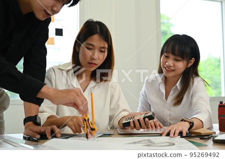 Team of experienced architects working together on new project in modern office interior Team of experienced architects working together on new project in modern office interior 95269492