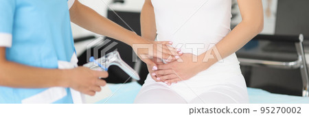 Gynecologist touches the belly of a sitting woman, close-up Gynecologist touches the belly of a sitting woman, close-up 95270002