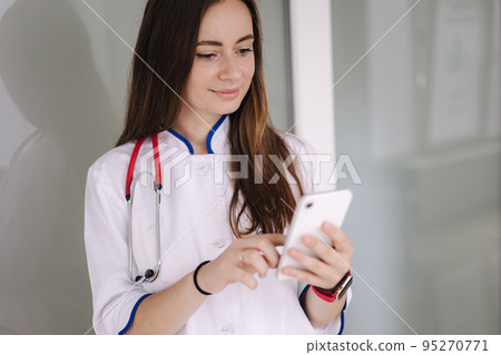 Portrait of youg female doctor using phone during break in clicic 95270771