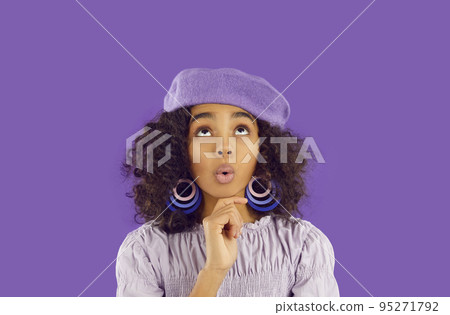 Young African American girl with delight and surprise looks up at copy space, WOW emotions 95271792