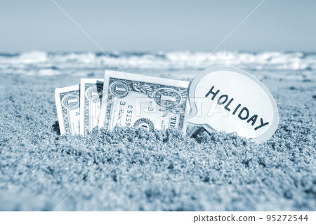 Paper bills one dollar and small stick with paper speech bubble with word Holiday buried in sand beach background sea, sunny summer day. Concept Money travel tourism vacation holiday relax. Blue color Paper bills one dollar and small stick with paper speech bubble with word Holiday buried in sand beach background sea, sunny summer day. Concept Money travel tourism vacation holiday relax. Blue color 95272544