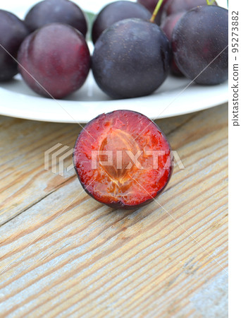 Ripe sliced plums 95273882