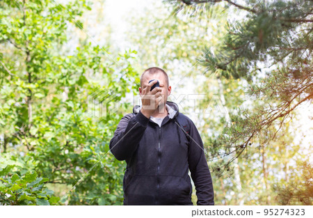 A man with a navigator in the forest. Location orientation. GPS signal reception. A man with a navigator in the forest. Location orientation. GPS signal reception. 95274323