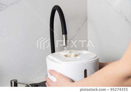 refilling the air freshener container with tap water. Air freshener. Copy space for text refilling the air freshener container with tap water. Air freshener. Copy space for text 95274355