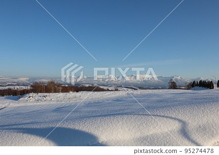 Biei, the Tokachi mountain range beyond the snowy fields 95274478