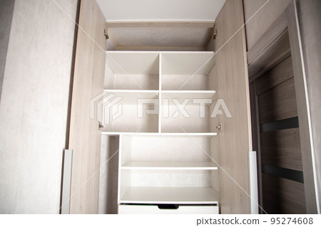 Modern closet in the hallway with hinged doors and pull-out shelves. Production of furniture under the order. 95274608