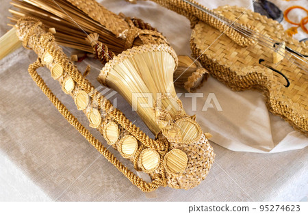 Saxophone and violin made of straw. Handmade, tradition. Close-up 95274623
