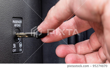Man turns off front passenger airbag with key, macro 95274870