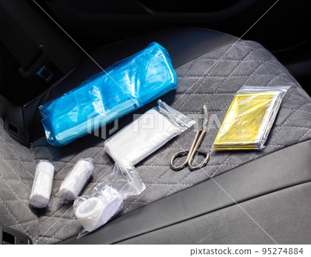 car first aid kit on the car seat. The list of medicines and the shelf life of medicines in the car first aid kit, close-up 95274884