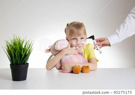 Doctor ENT doctor conducts an otoscopy with a device, close-up. Treatment and routine examination of the ear membranes and ear canals. Girl 5 years old 95275173