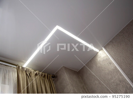 Diode lighting in the corners of the ceiling in an apartment with a stretch ceiling. Modern design, close-up Diode lighting in the corners of the ceiling in an apartment with a stretch ceiling. Modern design, close-up 95275190
